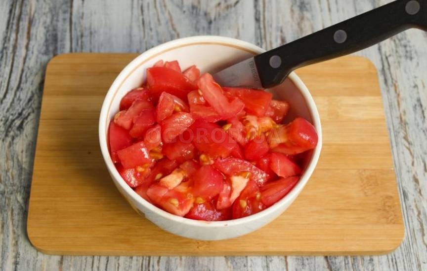 Очищенные и нарезанные помидоры добавляем к луку
